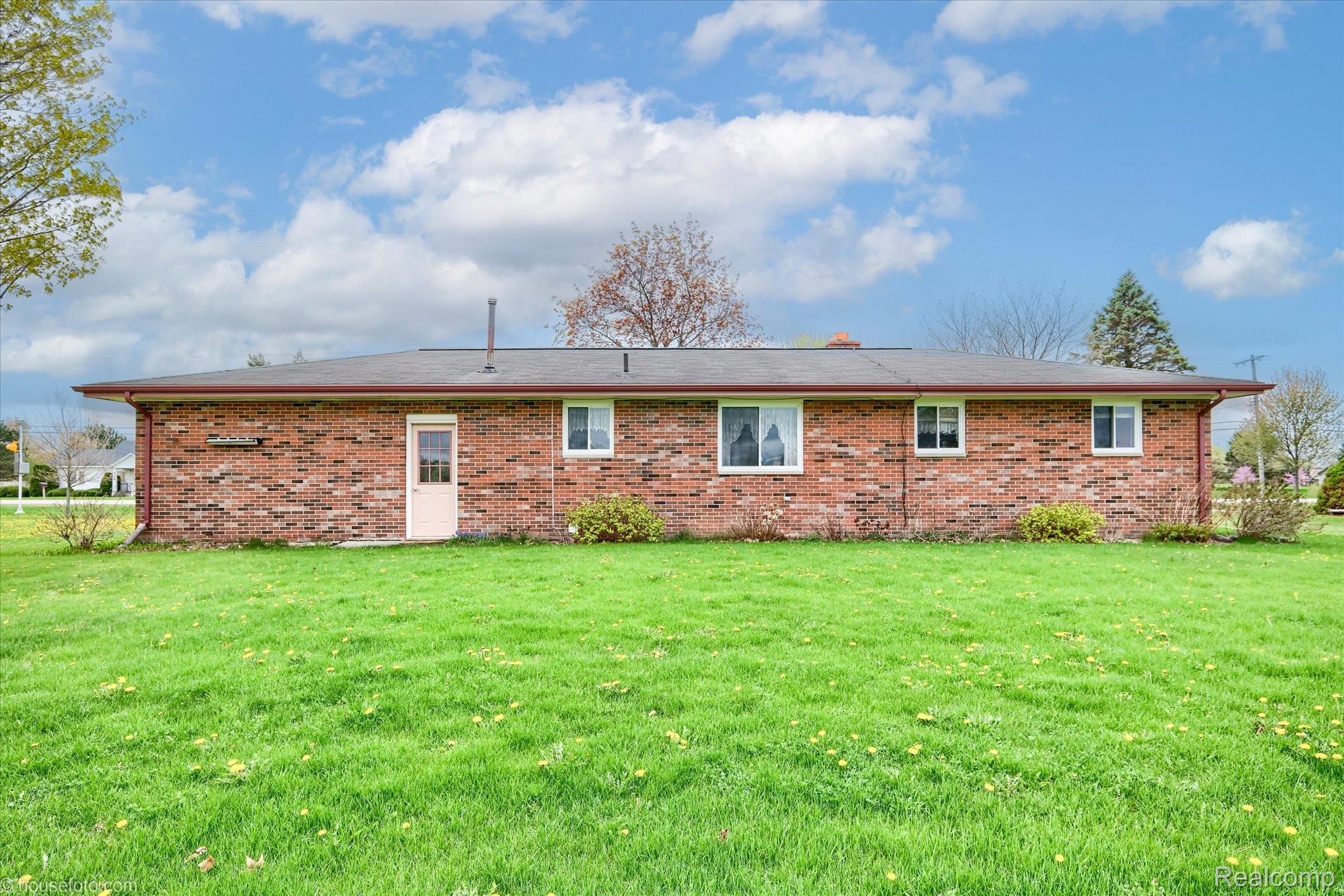 6080 Shattuck Road Saginaw, MI 48603 - Photo 5 of 35 Back of property with brick siding and a lawn