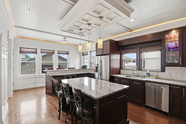 a kitchen with granite countertop a center island and a table in it