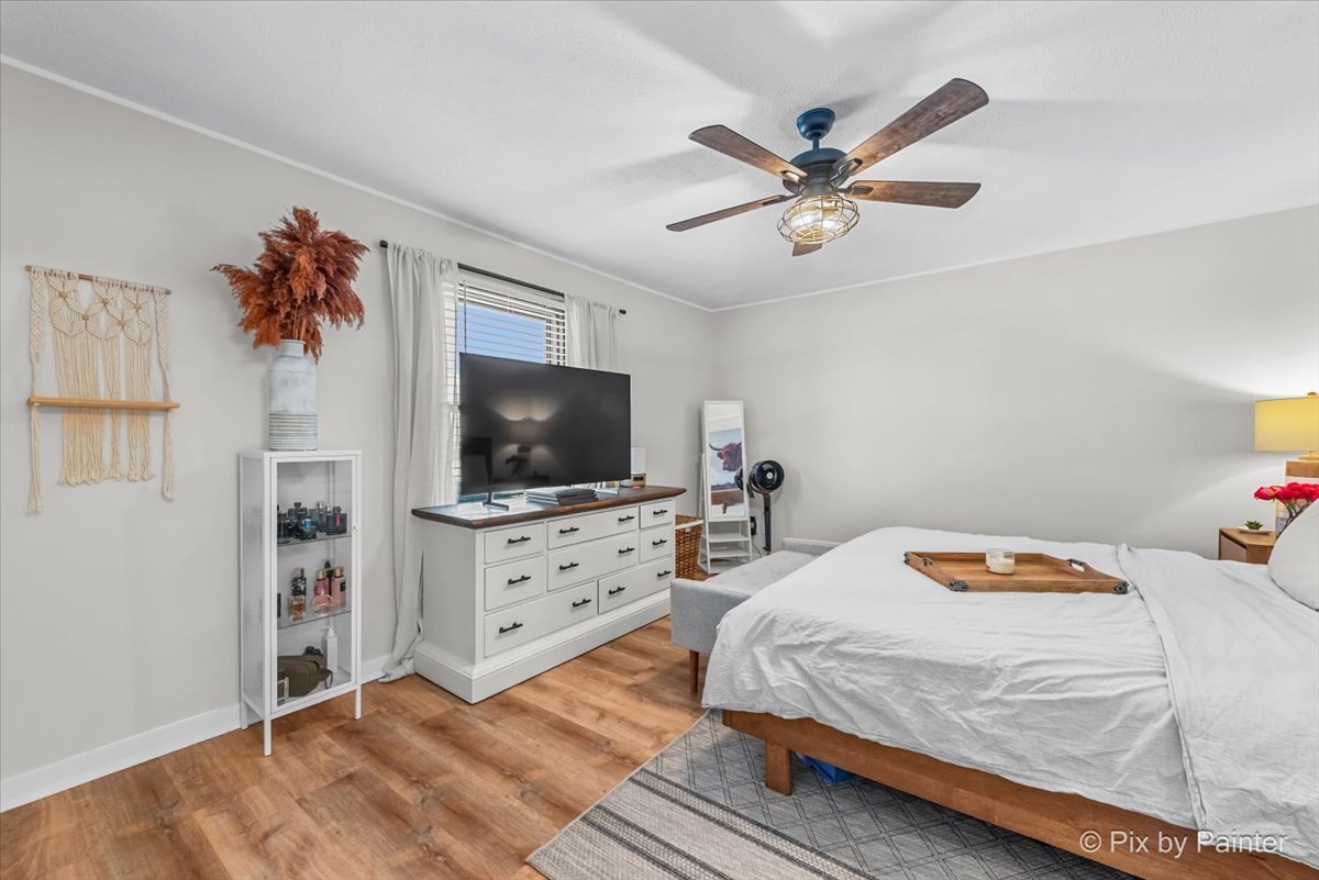 117 Benedict Drive Southwest Poplar Grove, IL 61065 - Photo 11 of 27 a bedroom with a bed a chandelier and a flat screen tv