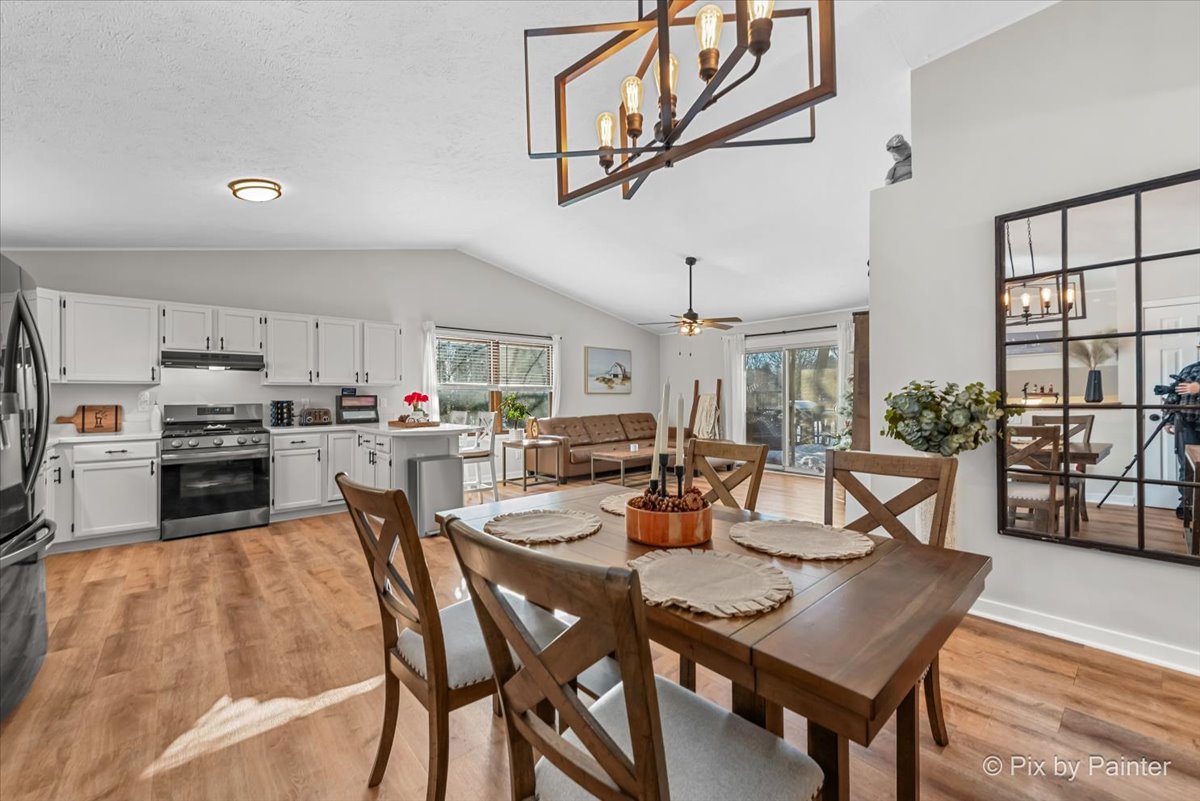 117 Benedict Drive Southwest Poplar Grove, IL 61065 - Photo 8 of 27 a kitchen with a dining table chairs and stove