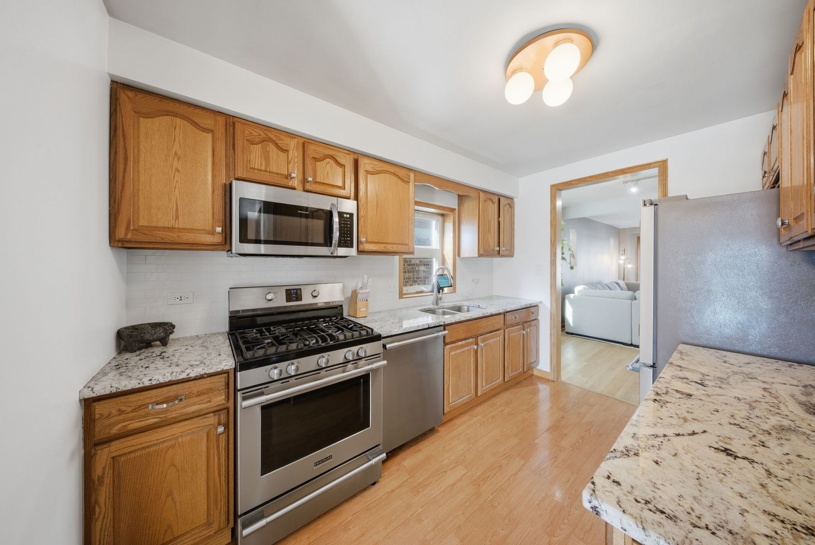 5325 North Meade Avenue Chicago, IL 60630 - Photo 3 of 24 a kitchen with stainless steel appliances granite countertop a stove and a sink