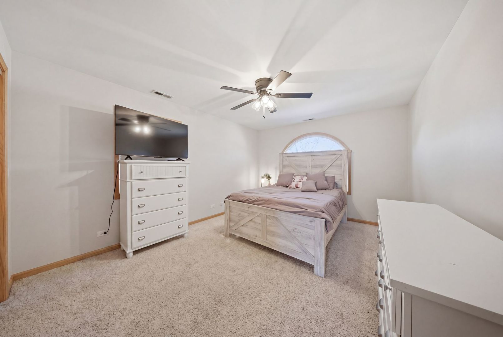 5325 North Meade Avenue Chicago, IL 60630 - Photo 9 of 24 a bedroom with a bed and a flat tv screen on dresser