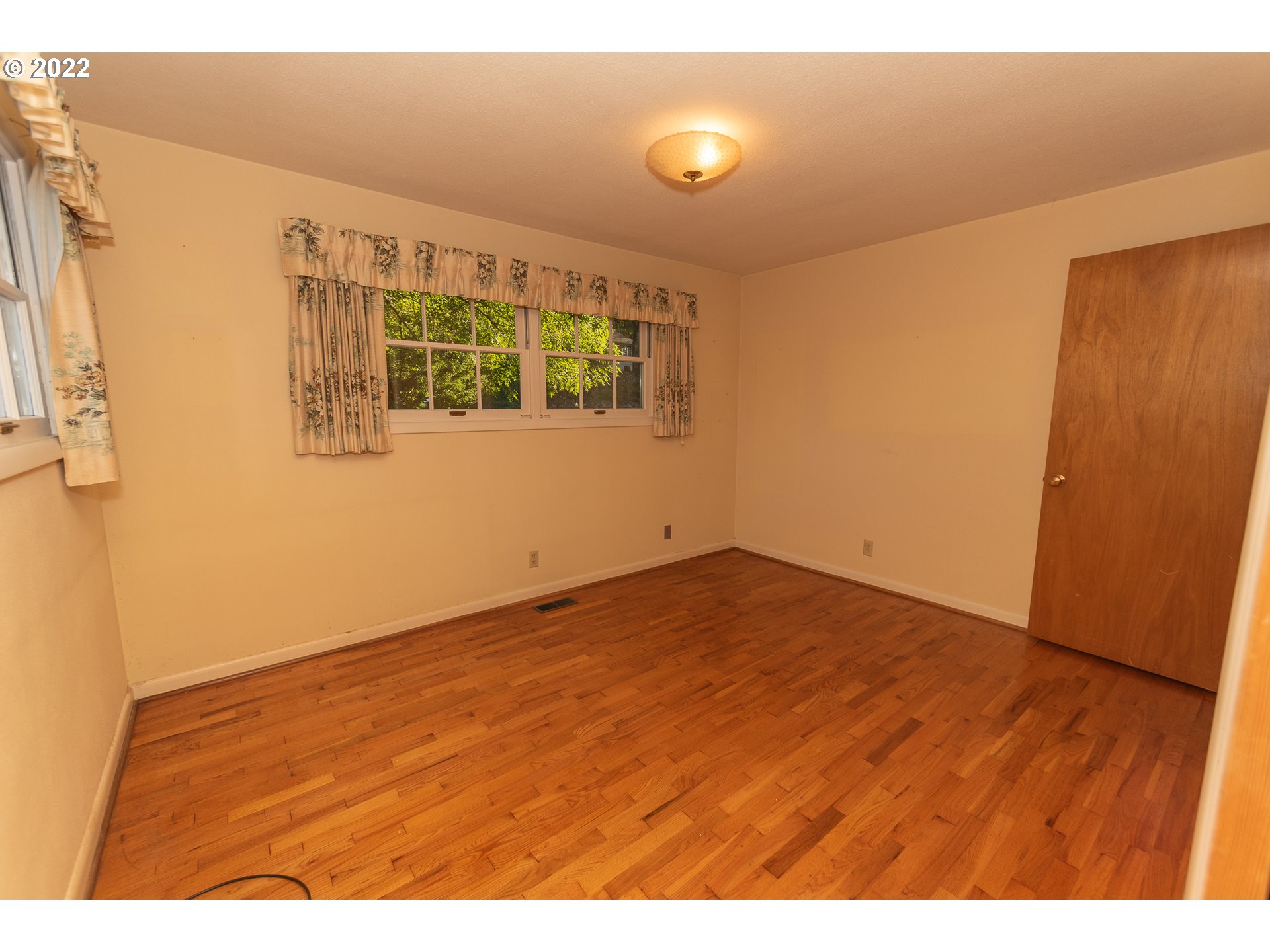 565 East 39th Place Eugene, OR 97405 - Photo 13 of 19 a view of an empty room with wooden floor and a window