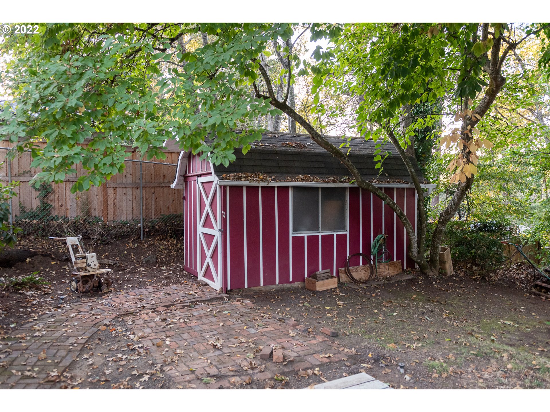 565 East 39th Place Eugene, OR 97405 - Photo 18 of 19 a view of a backyard with large trees and wooden fence