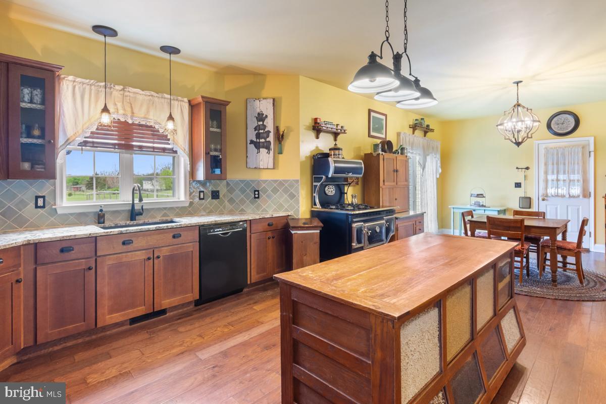 31 Quail Court Littlestown, PA 17340 - Photo 8 of 26 a kitchen with a stove a sink dishwasher a kitchen island with wooden cabinets and floor