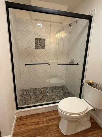 a bathroom with a toilet and a shower