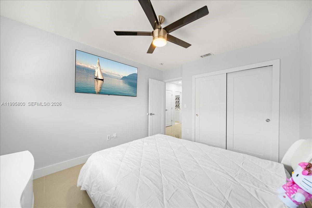 15341 Southwest 36th Street Miami, FL 33185 - Photo 45 of 56 a bedroom with a bed and a chandelier