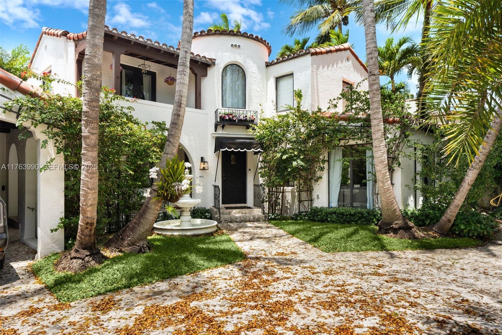 4430 Alton Road Miami Beach, FL 33140 - Photo 42 of 47 a front view of a white house with a yard and potted plants