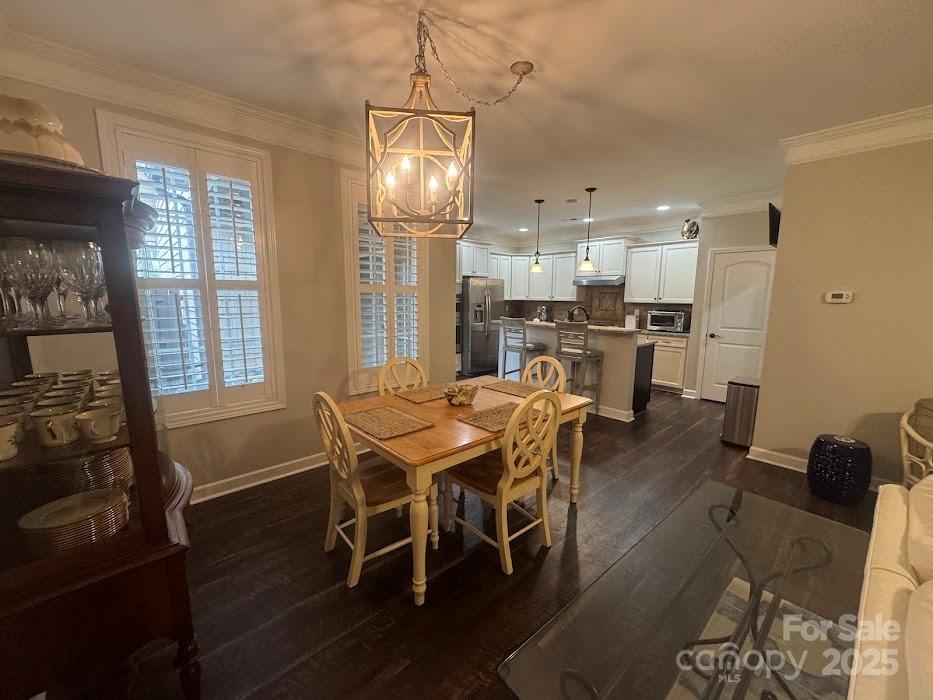 2279 Eversham Drive Northwest Concord, NC 28027 - Photo 7 of 28 a dining room with wooden floor a chandelier a wooden table and chairs