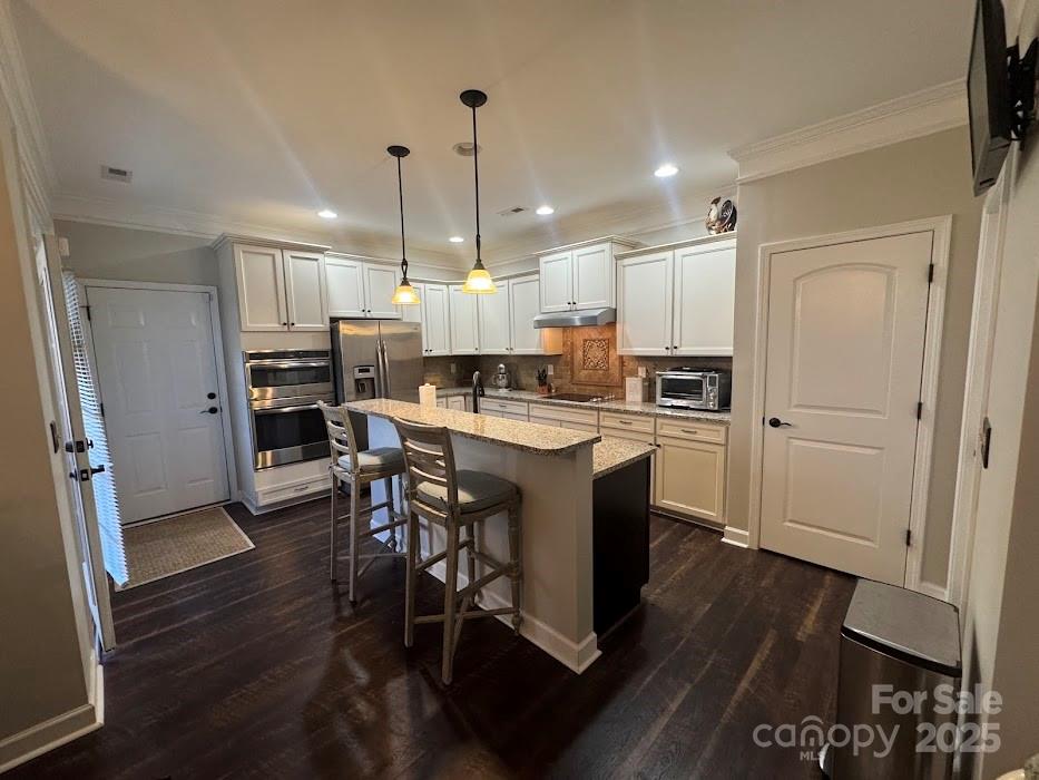 2279 Eversham Drive Northwest Concord, NC 28027 - Photo 8 of 28 a kitchen with stainless steel appliances kitchen island granite countertop a refrigerator a stove a sink a dining table and chairs with wooden floor