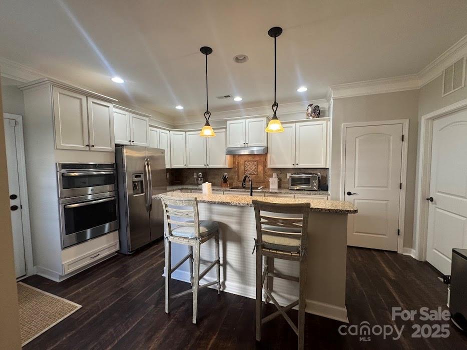 2279 Eversham Drive Northwest Concord, NC 28027 - Photo 9 of 28 a kitchen with stainless steel appliances a dining table chairs stove and white cabinets