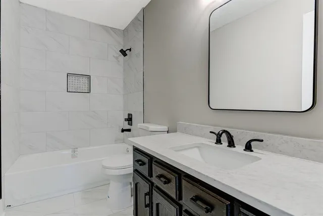 a bathroom with a sink double vanity granite tub and a mirror