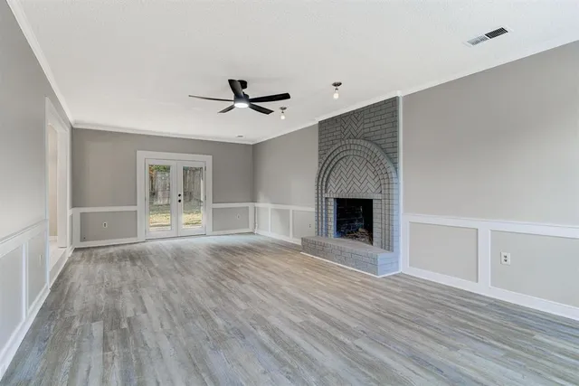 a view of empty room with wooden floor and fireplace