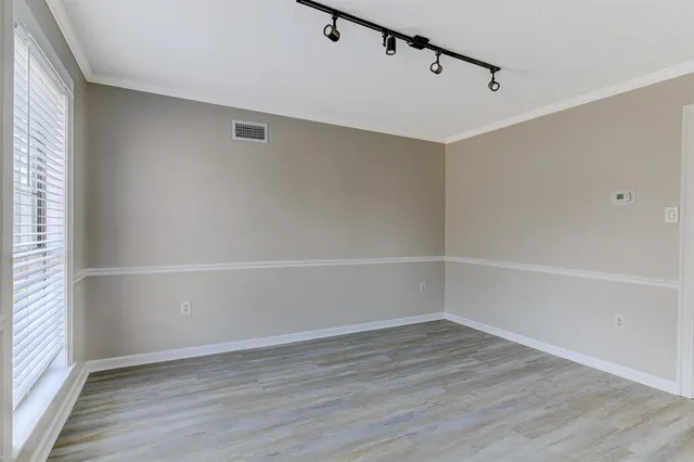 a view of a room with wooden floors and white walls