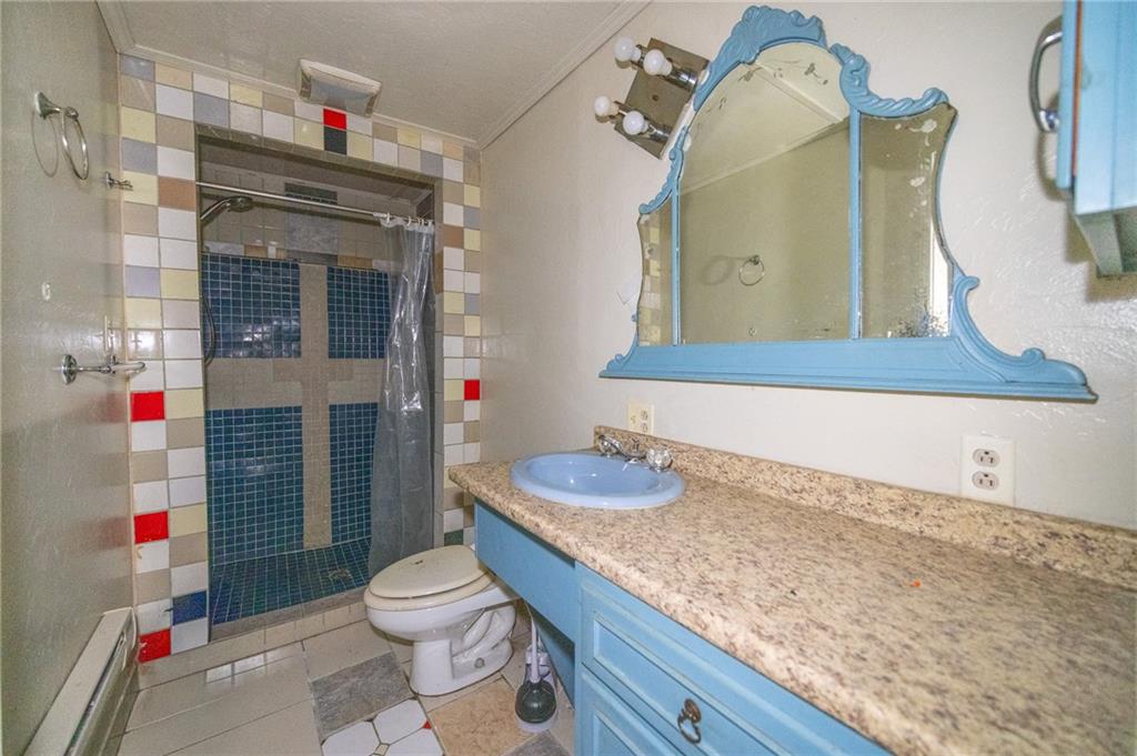 511 2nd Street Monessen, PA 15062 - Photo 16 of 21 a bathroom with a granite countertop sink a toilet and a shower curtain