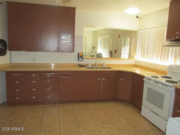 a large kitchen with granite countertop a sink a stove and cabinets