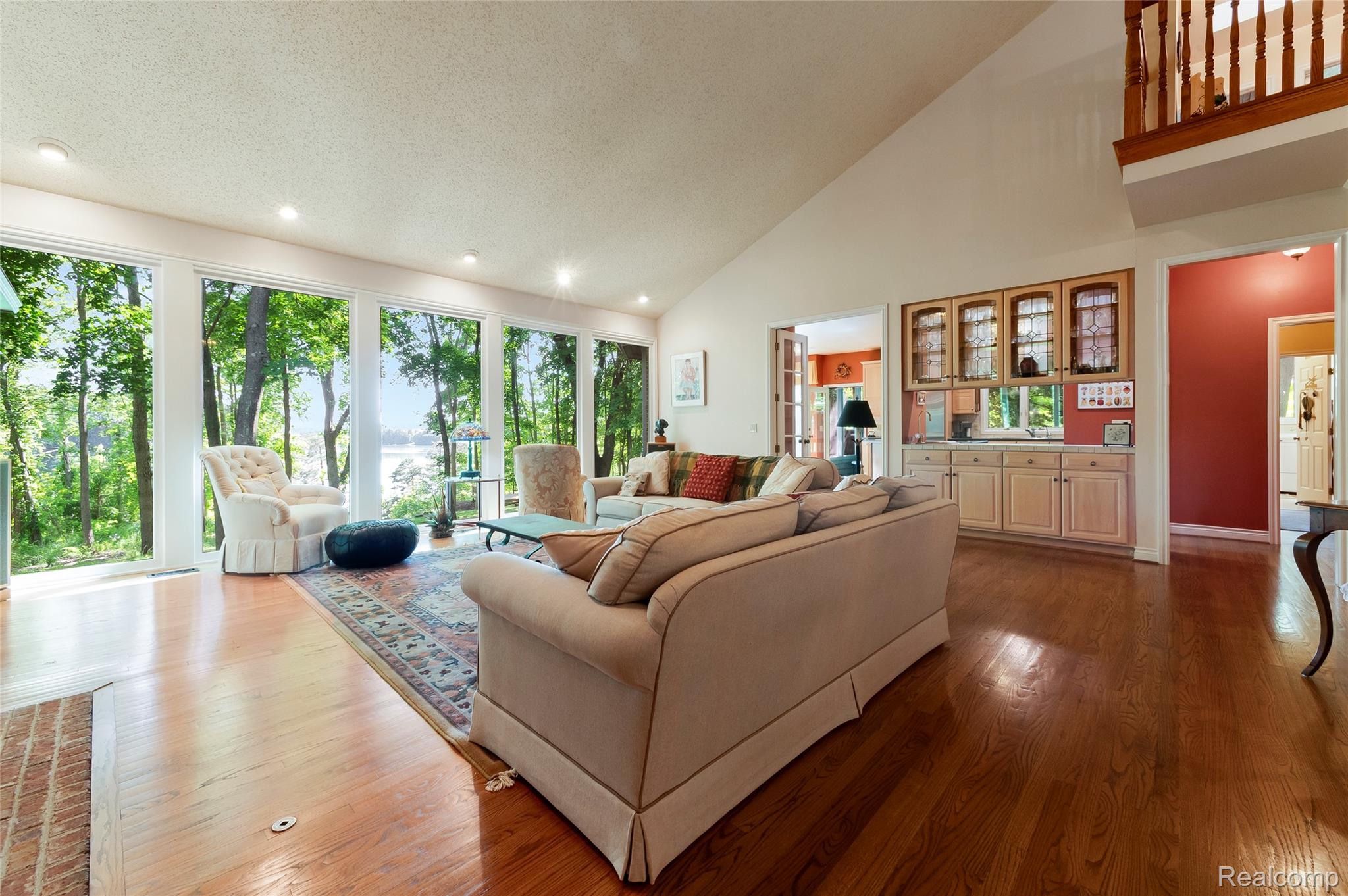 2323 Addaleen Road Highland, MI 48357 - Photo 28 of 70 Living space featuring extensive wall of windows, wood-finish flooring, a vaulted ceiling, wet bar and recessed lighting