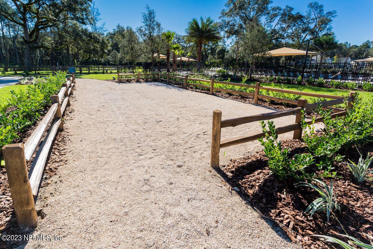 515 Park Forest Drive Ponte Vedra, FL 32081 - Photo 86 of 106 a view of a swimming pool with a table and chairs under an umbrella