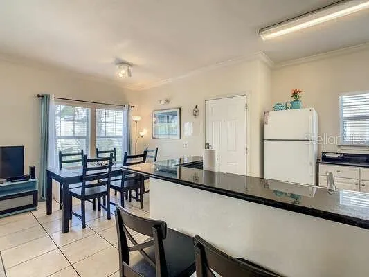 a kitchen with a table chairs and a refrigerator