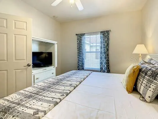a bedroom with a flat screen tv and a bed