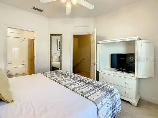 a bedroom with a bed and a lamp on dresser