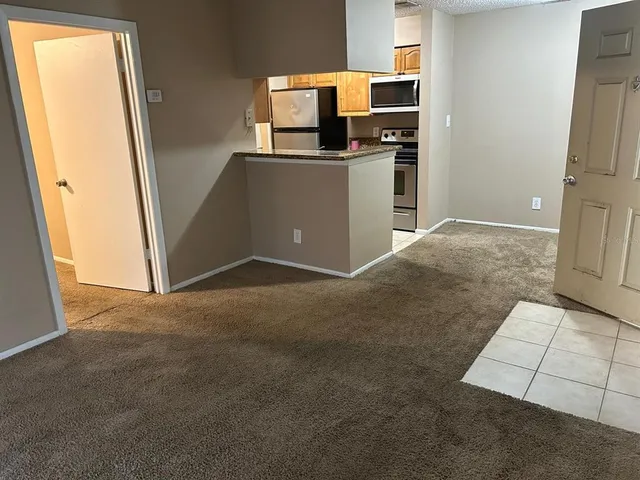 a view of kitchen with sink and refrigerator