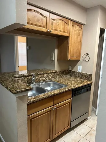 a kitchen with granite countertop a sink and cabinets