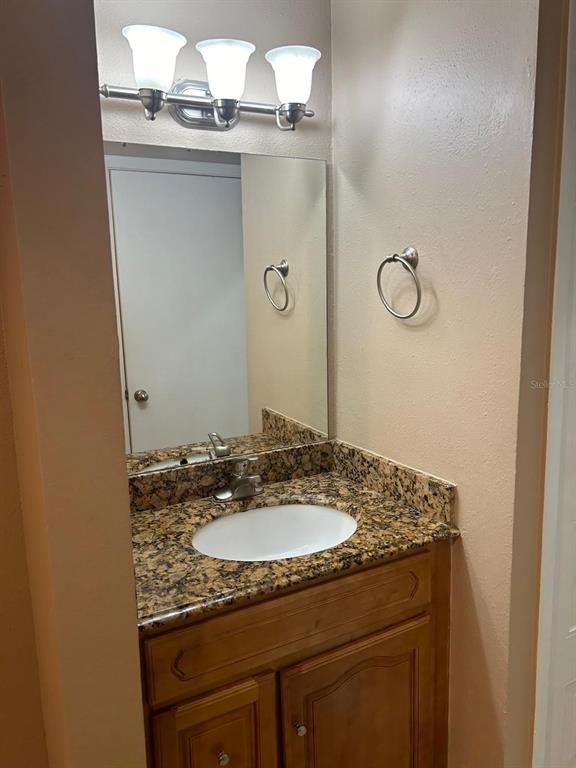 238 Afton Square, Unit 305 Altamonte Springs, FL 32714 - Photo 9 of 13 a bathroom with a granite countertop sink and a mirror