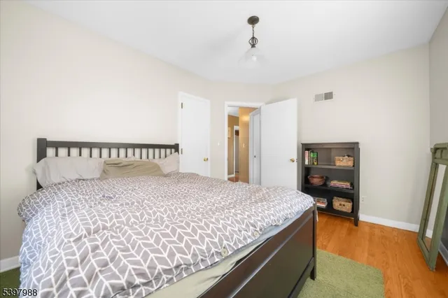 a bedroom with a large bed and wooden floor