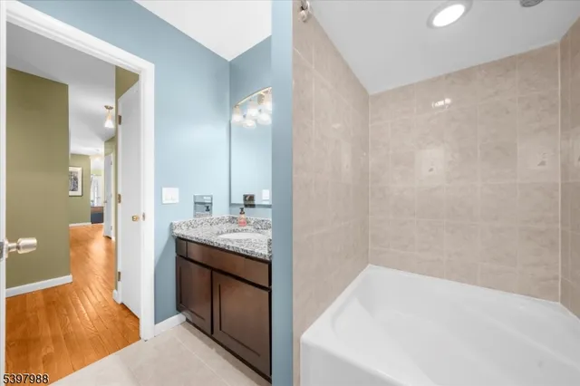 a bathroom with a tub sink and mirror
