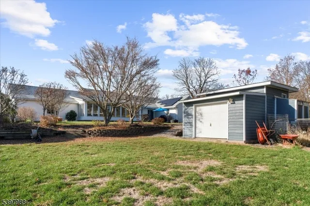 a front view of house with yard and trees in the background
