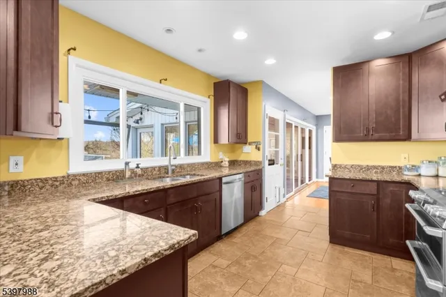 a large kitchen with granite countertop a sink and cabinets