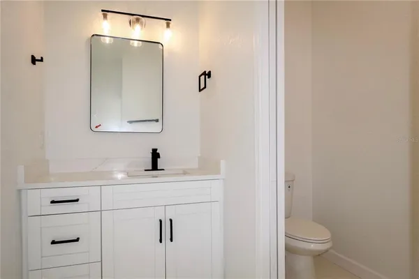 a bathroom with a sink a toilet and a mirror