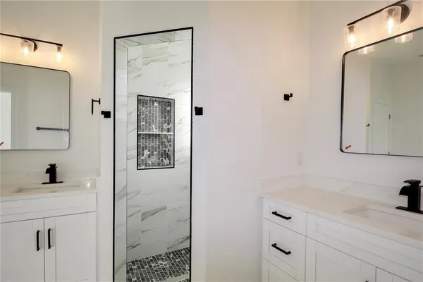 a bathroom with a shower sink and mirror