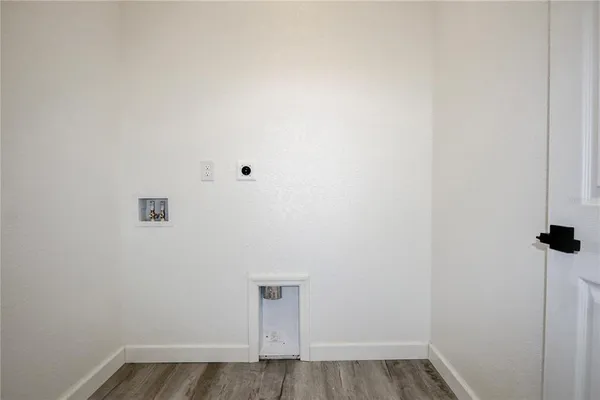 a view of a small space with wooden floor and a window