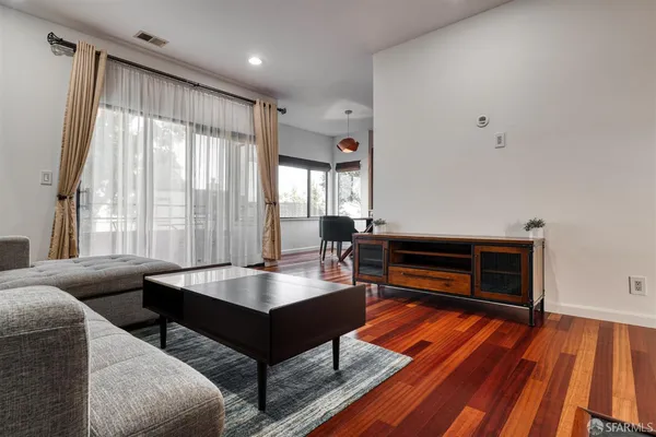 a living room with furniture and a wooden floor