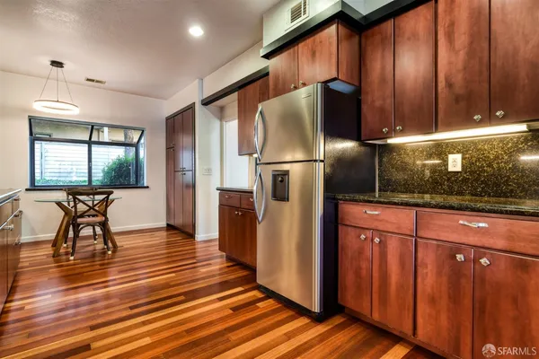 a kitchen with stainless steel appliances granite countertop a refrigerator a stove and a microwave