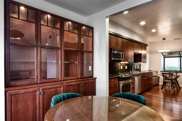 a room with wooden floor table and chairs