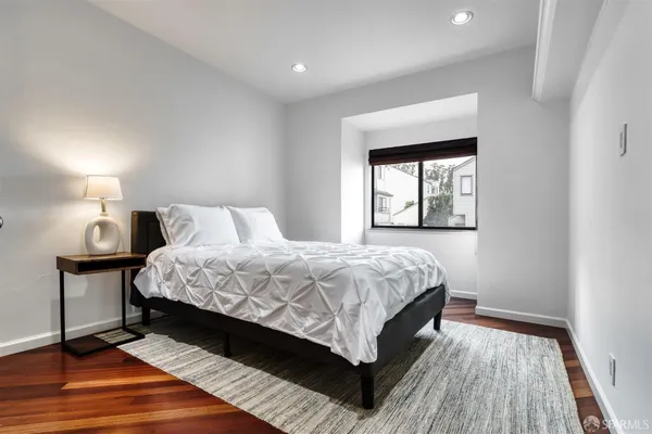 a bedroom with a large bed and a wooden floor
