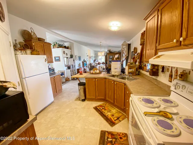 a very nice looking open kitchen with stainless steel appliances kitchen island granite countertop a refrigerator and a dining table
