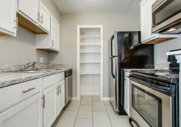 a kitchen with granite countertop a stove and a refrigerator