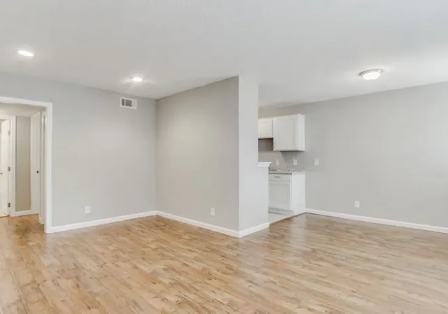 a view of empty room with wooden floor