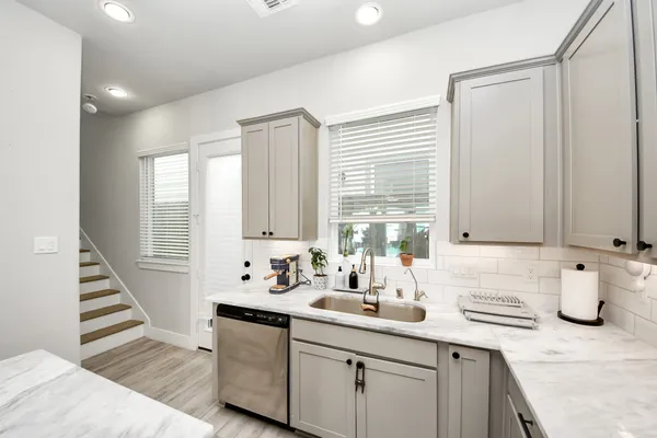 a kitchen with sink a window and cabinets