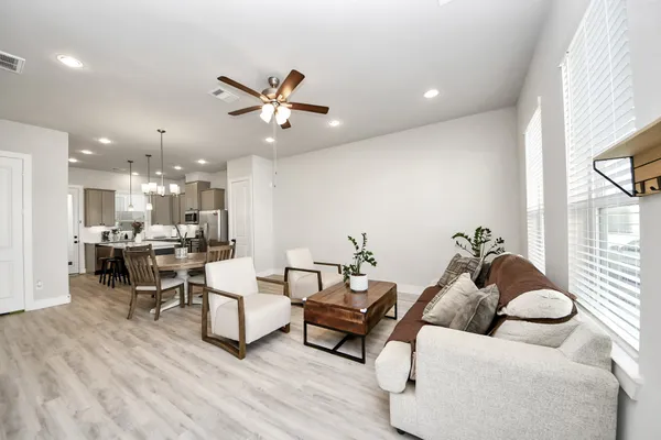 a living room with furniture and kitchen view