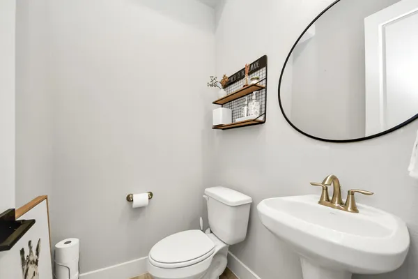 a bathroom with a toilet a sink and mirror