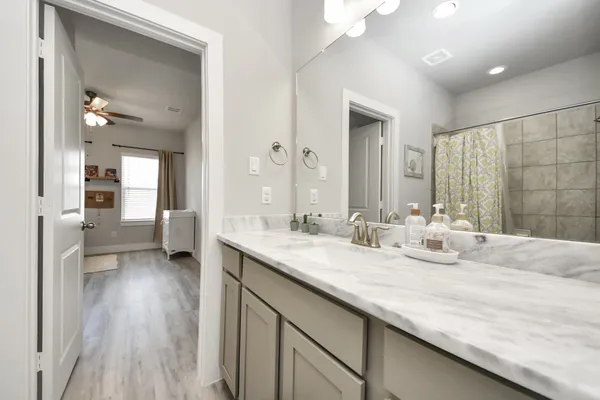 a en suite bathroom with a granite countertop sink and a mirror