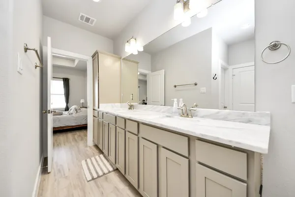 a en suite bathroom with a double vanity sink and a mirror