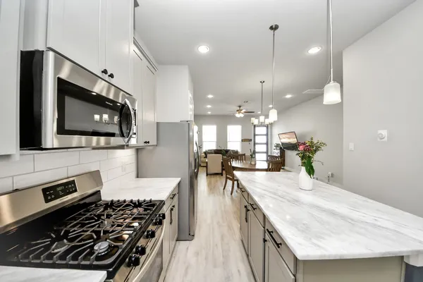 a kitchen with stainless steel appliances a stove a sink a microwave a stove and a microwave