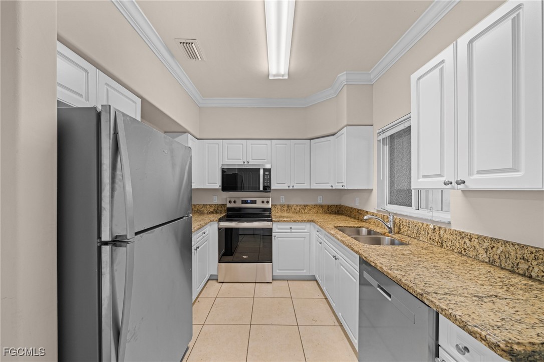 4172 Castilla Circle, Unit 206 Fort Myers, FL 33916 - Photo 7 of 37 a kitchen with stainless steel appliances granite countertop a refrigerator stove microwave and sink