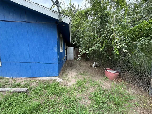 a view of a backyard with potted plants and wooden fence